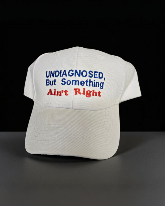 White Dad Cap with "Undiagnosed, But Something Ain't Right" Embroidered Letters